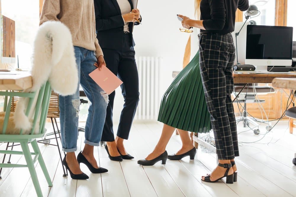 Four women standing together and talking.