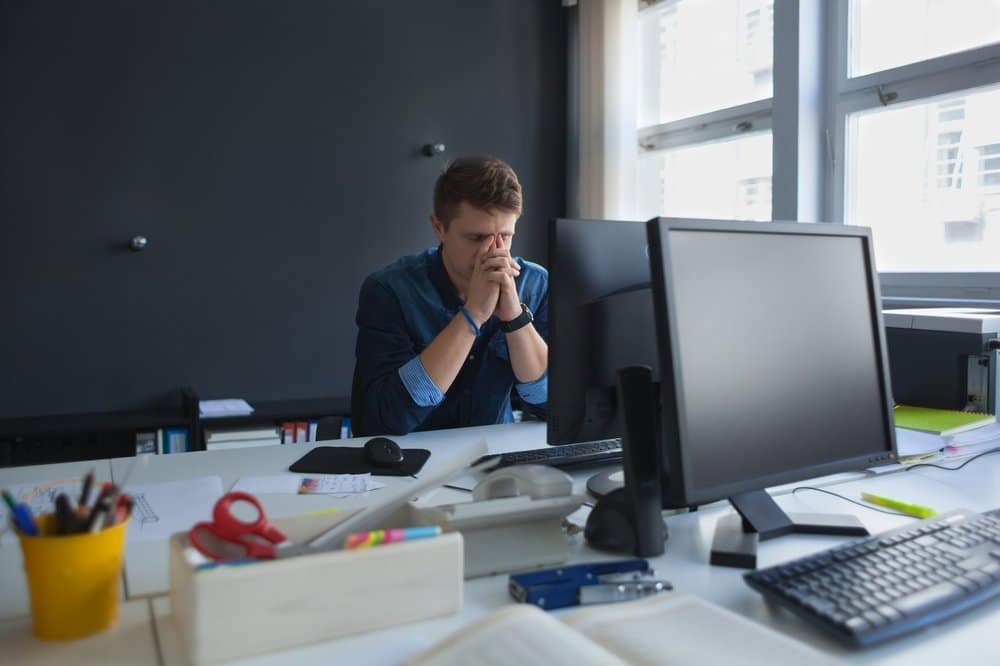 A man tired while working in the office.