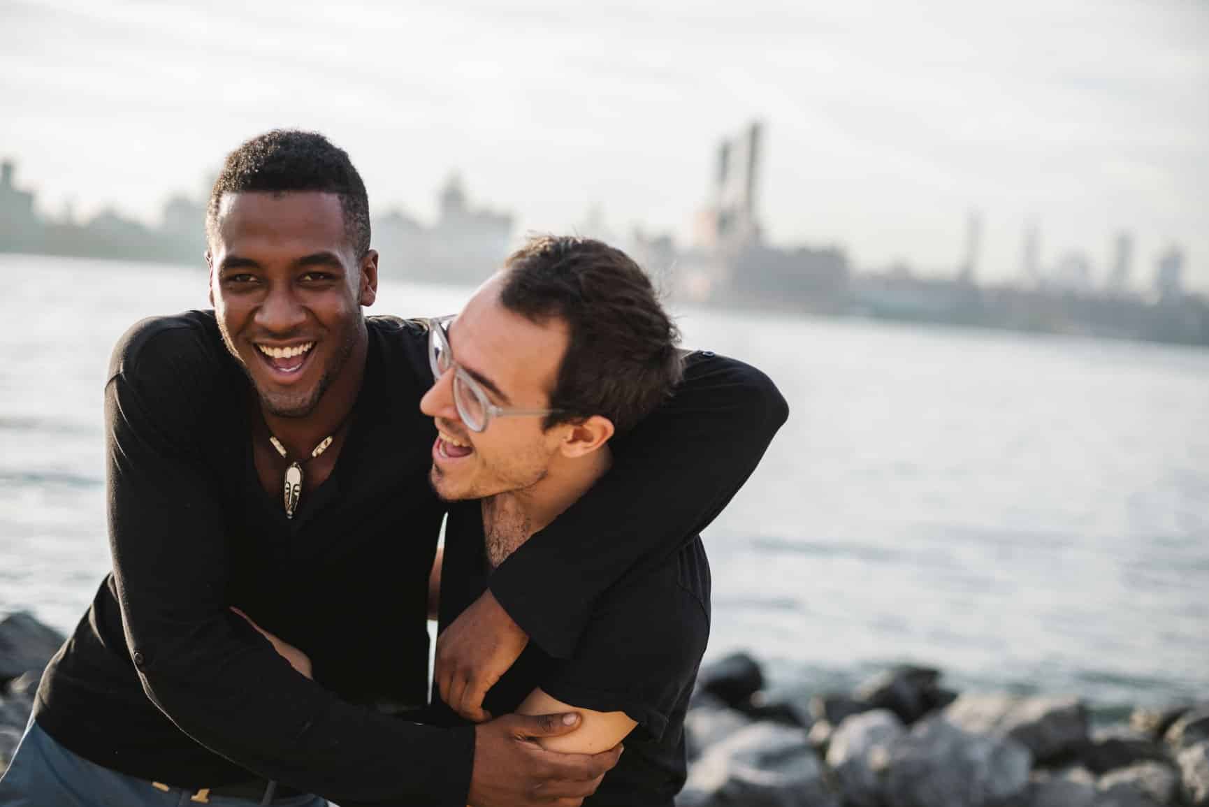 Two men laughing and hugging each other.