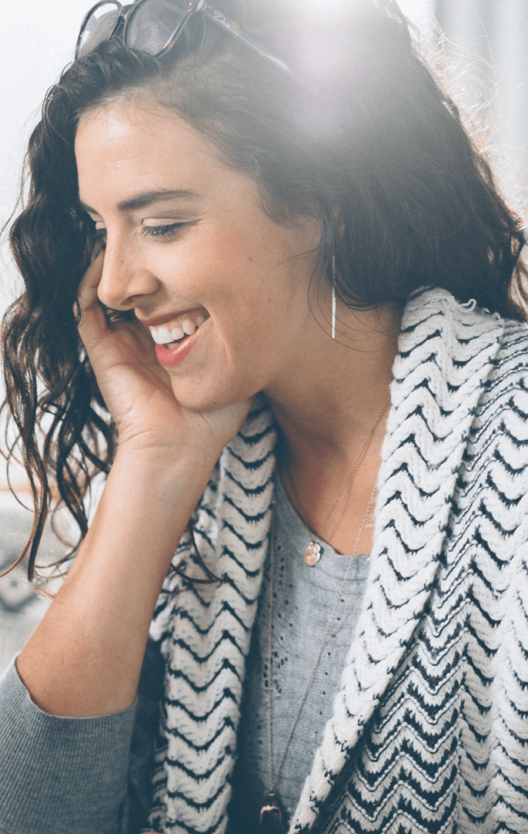 Woman smiling and looking off and down to the side.