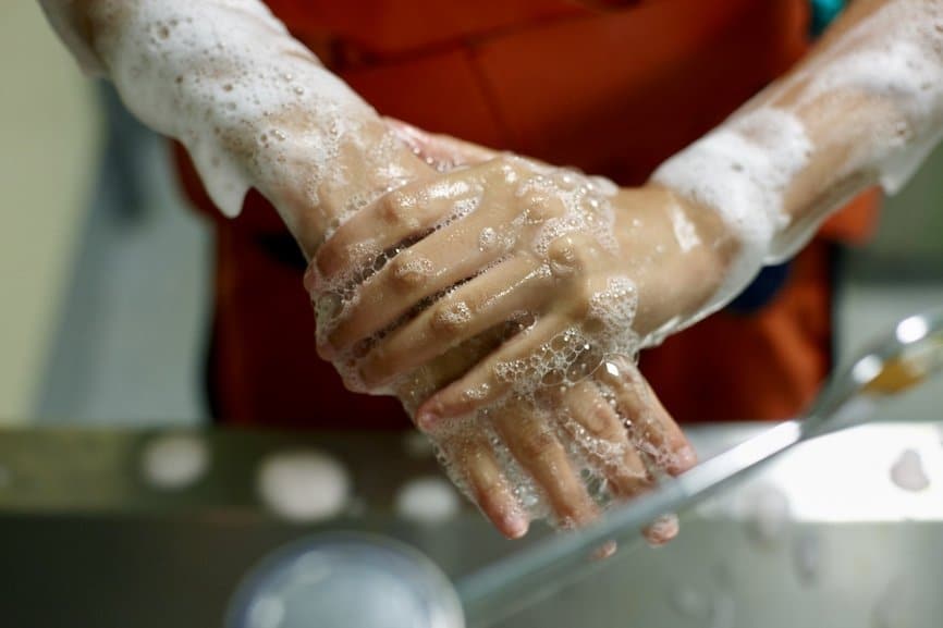 Close Up Of Two Hands Getting Washed With Soap.