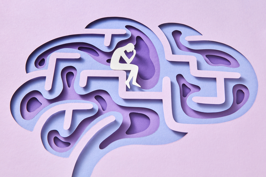 Handmade multicolored paper craft structure of labyrinth of human brain with paper thinker sitting inside on a light lavender background, copy space.