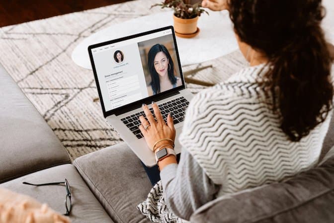 A woman from the back using her laptop to look at potential Lyra therapists.