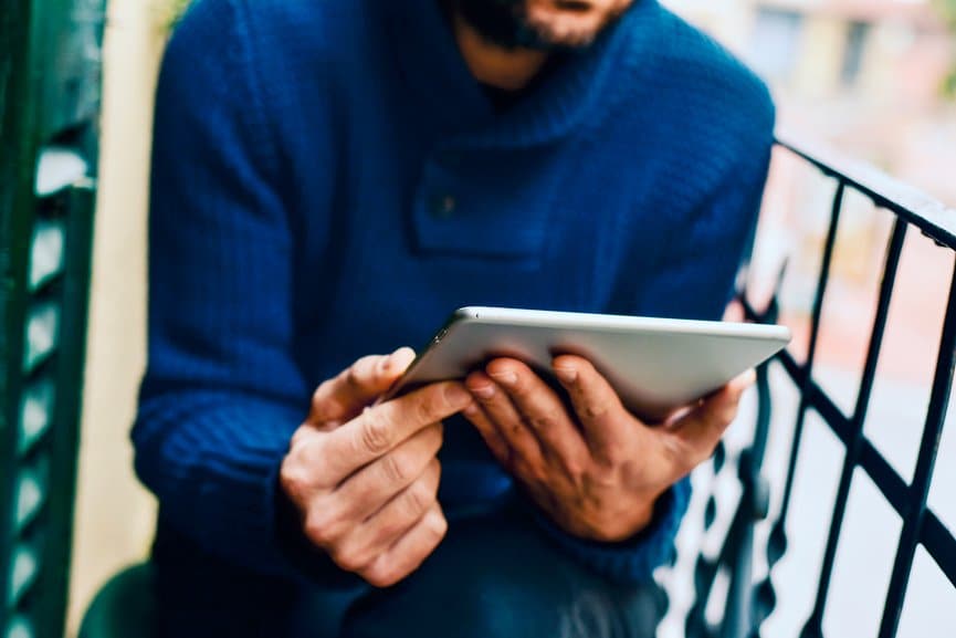 Man using a tablet on the balcony.