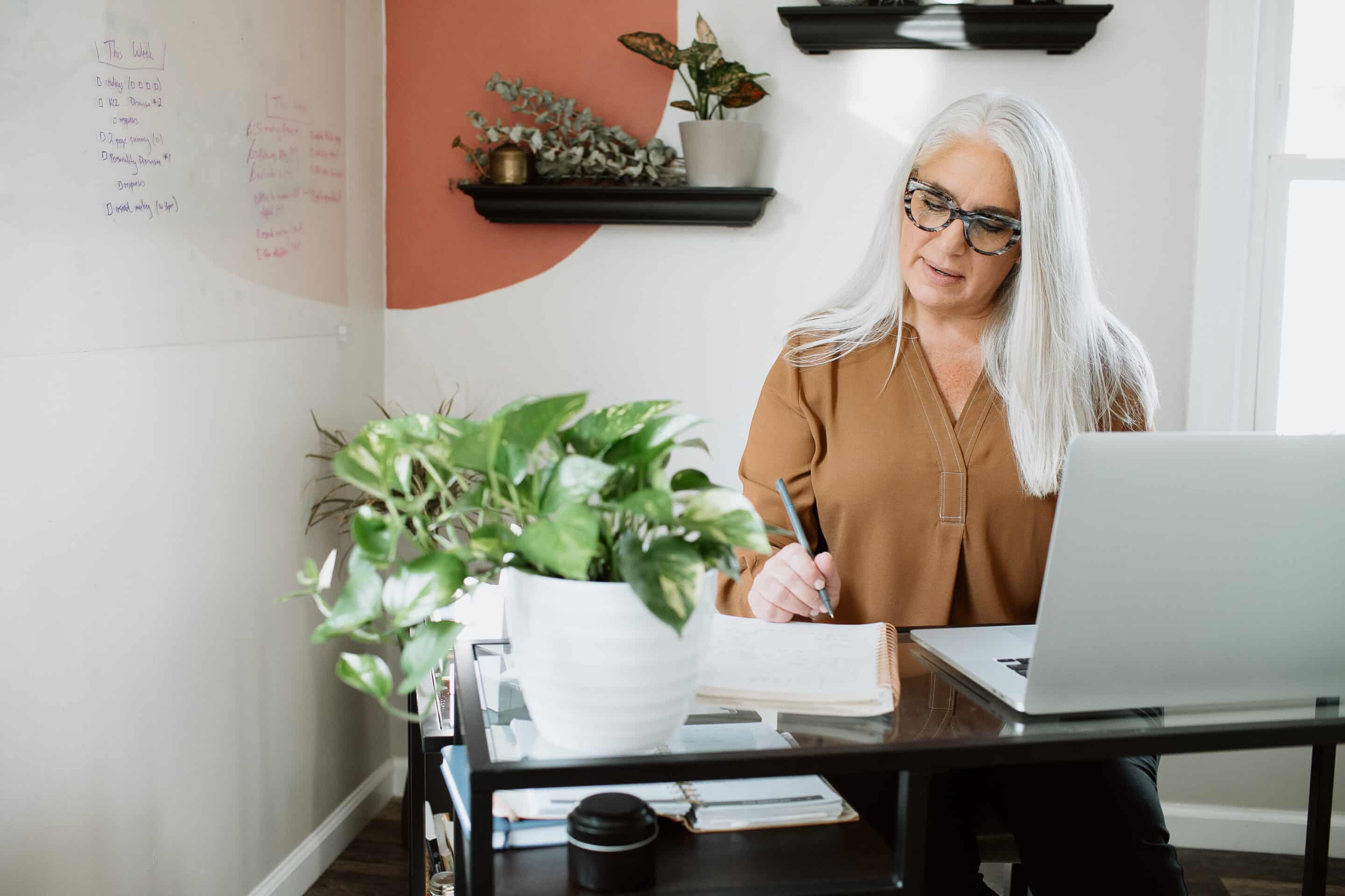 Woman taking notes at her desk.