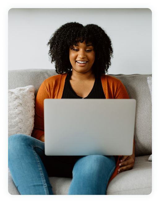 African American woman smiling at laptop