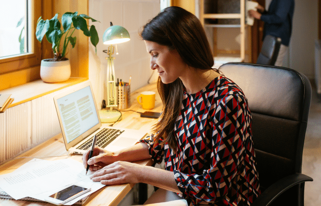 woman writing at her desk