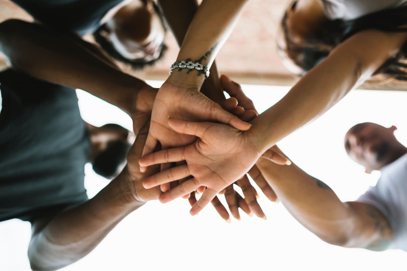 People with their hands together, ready to do a cheer.