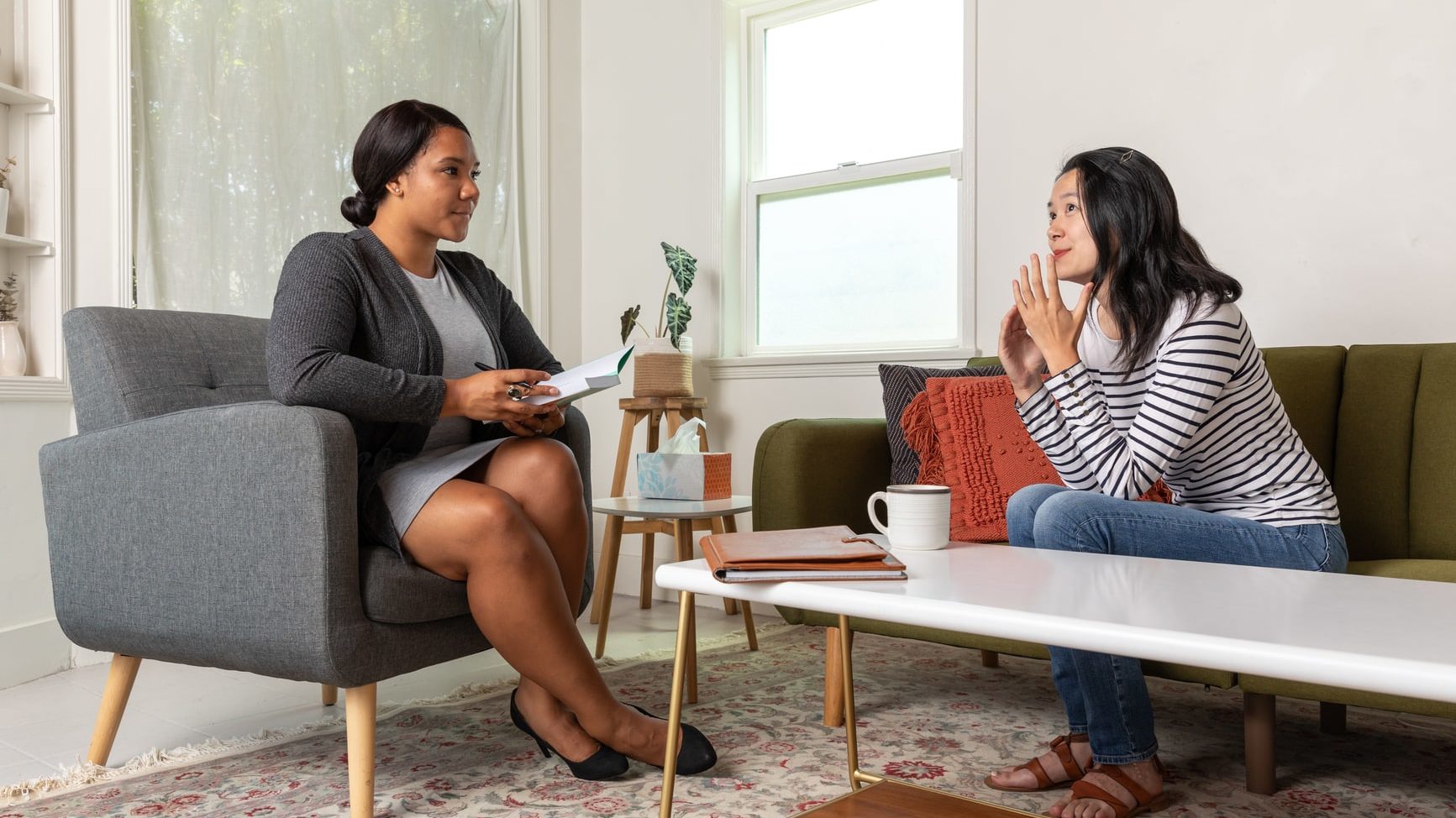 Talk therapist takes notes during client session.