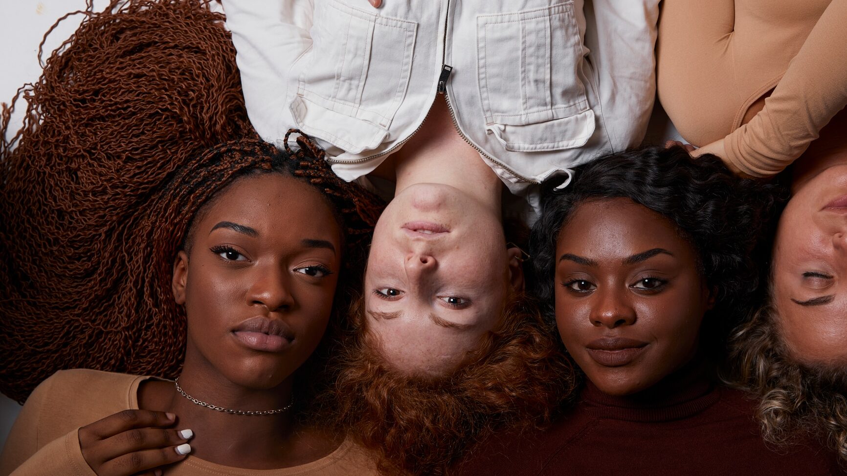 Top view portrait of a group in row of diverse multiracial females with different skin tones