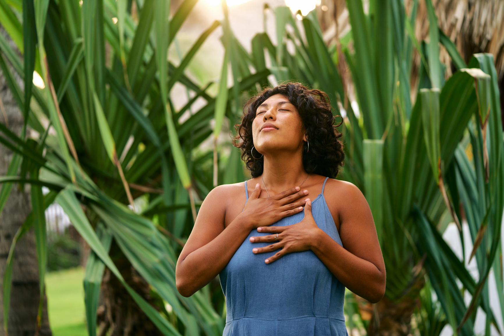 Young latina meditating and touching her body over natural background. Self care mind body and soul