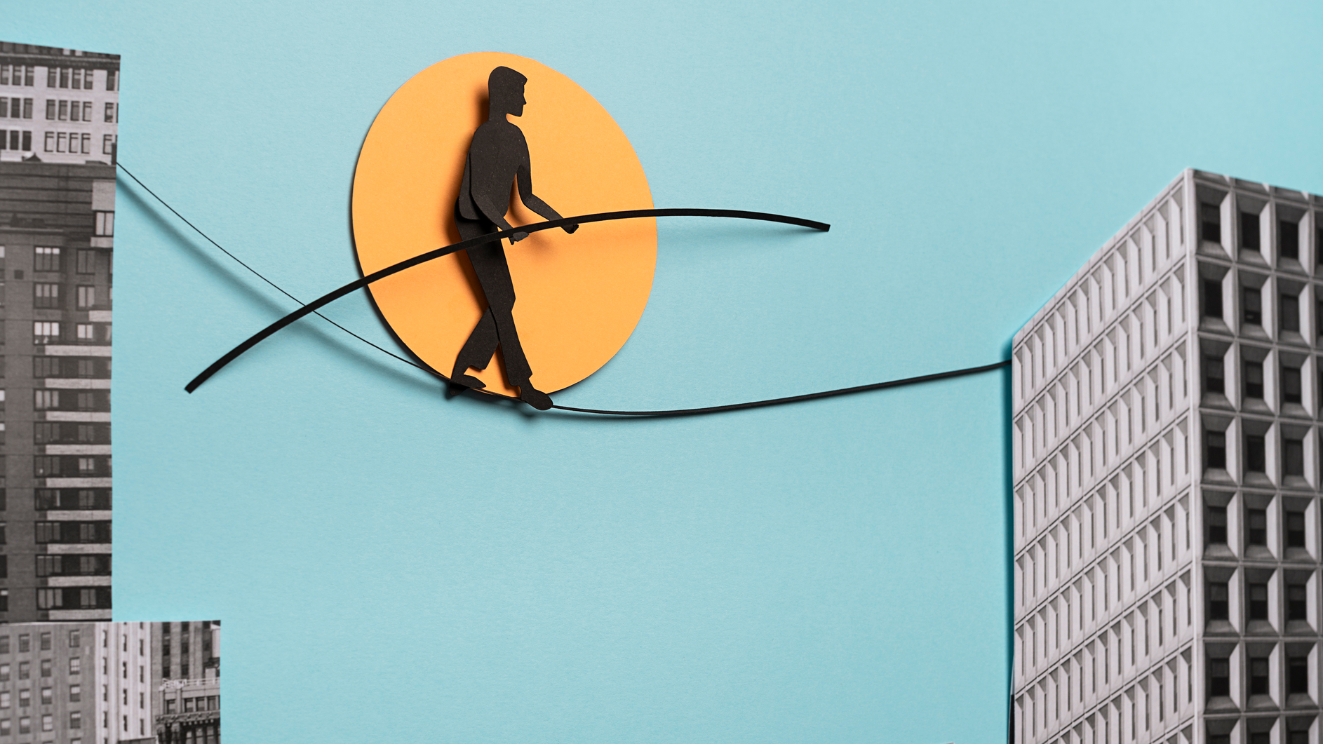 Man on wire, tightrope walker passing from one building to another