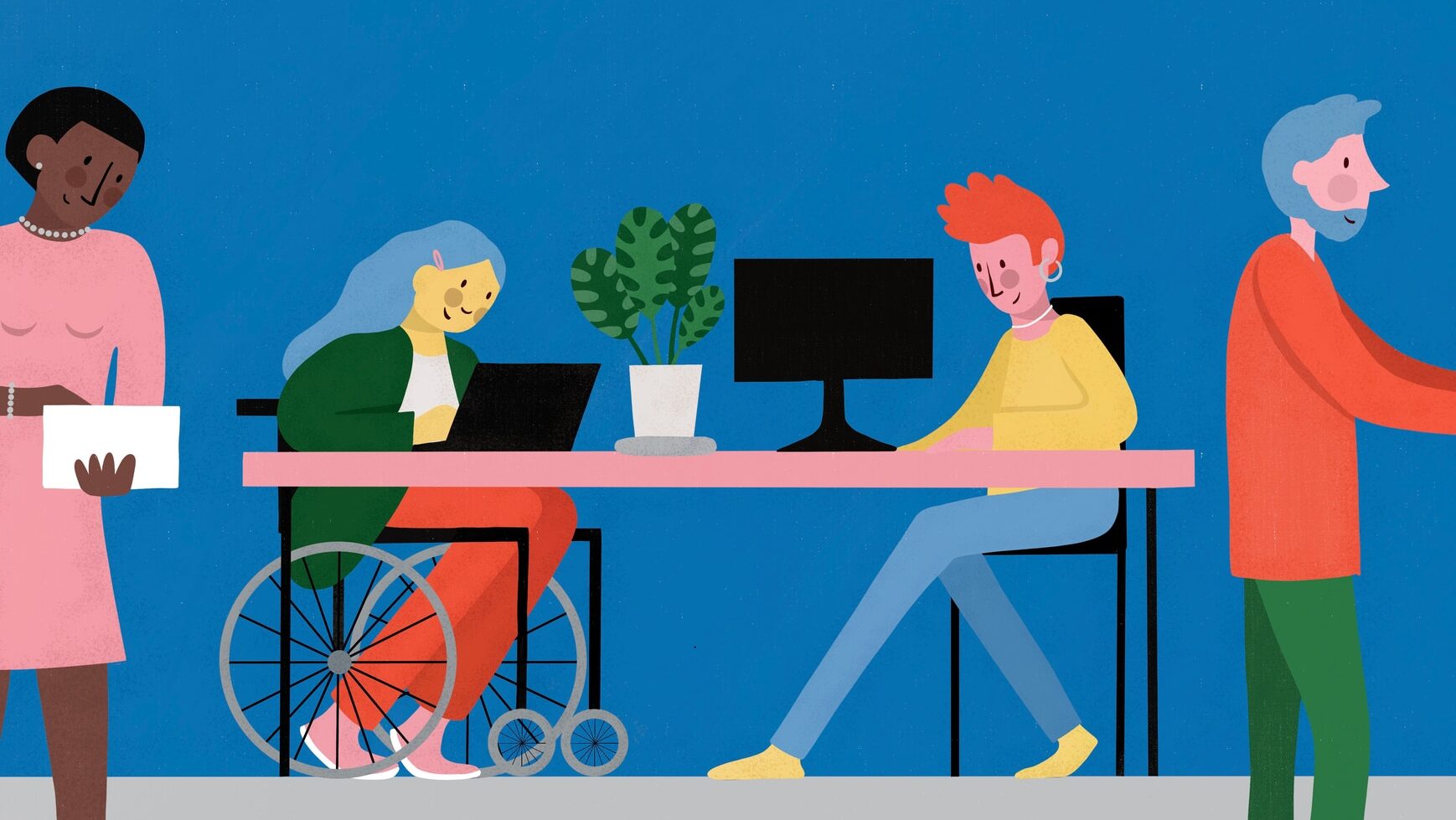 A busy office scene. Two people sit at a desk on their computers and laptop. One of them is in a wheelchair. Either side of them are two office workers who are busy working.