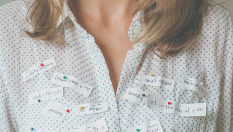 busy woman with reminders pinned to her shirt