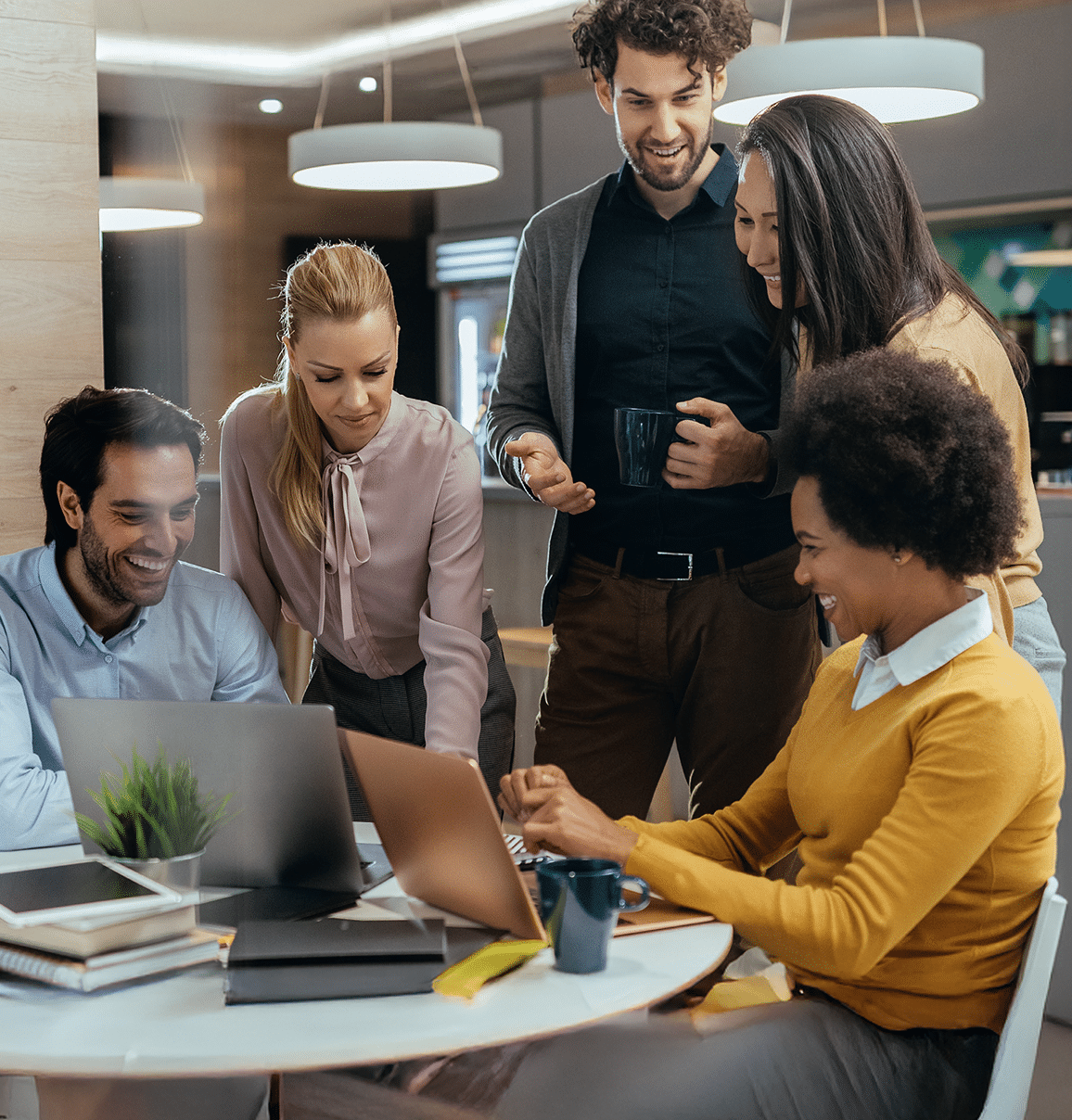 a group of people looking at a laptop together
