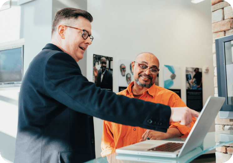 two people looking at a laptop