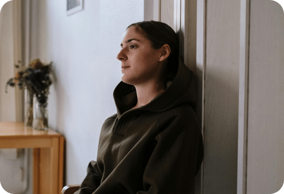 woman leaning against a wall looking upset