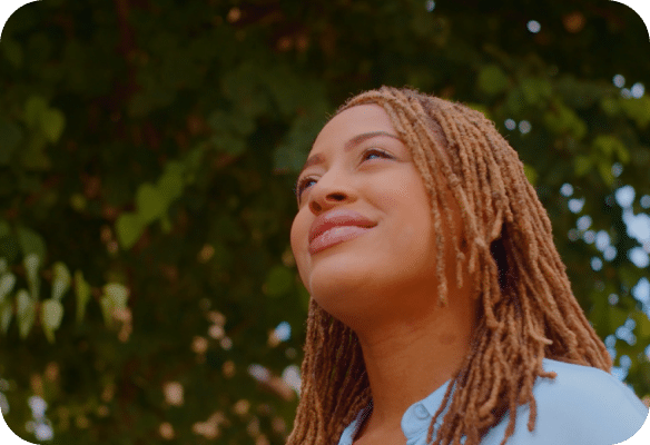 woman smiling underneath a tree