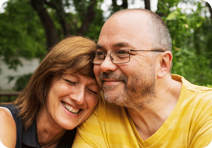 a woman and a man smiling with their heads together