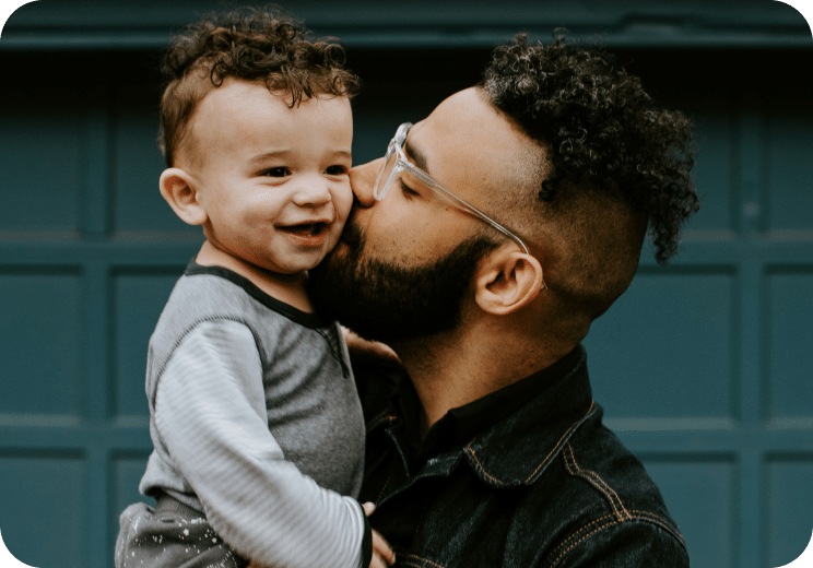 man kissing a baby on the cheek