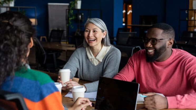 group of people sitting around a table smiling