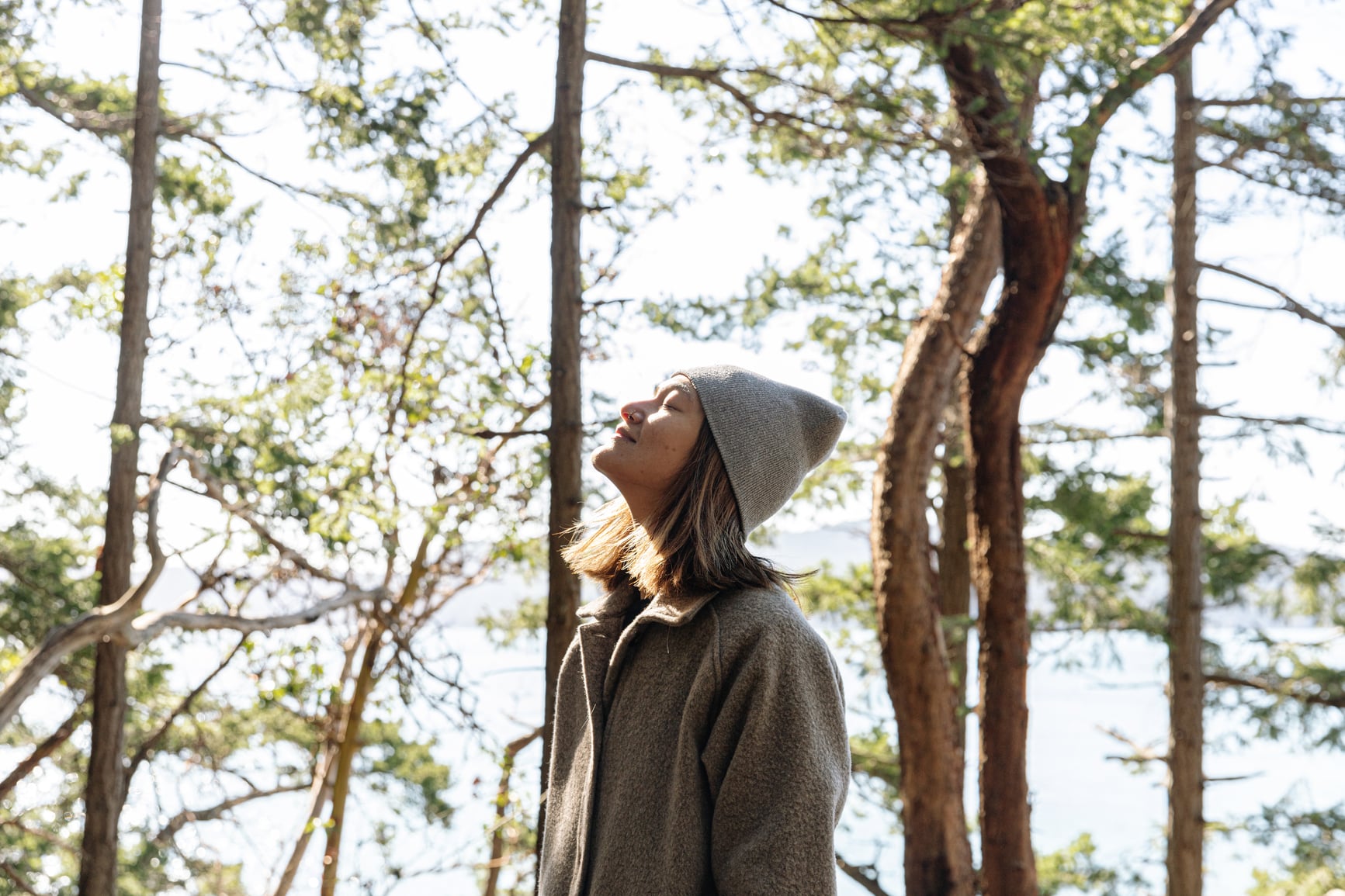 Young woman hiking and taking a moment to relax in forest. Vancouver Island, British Columbia